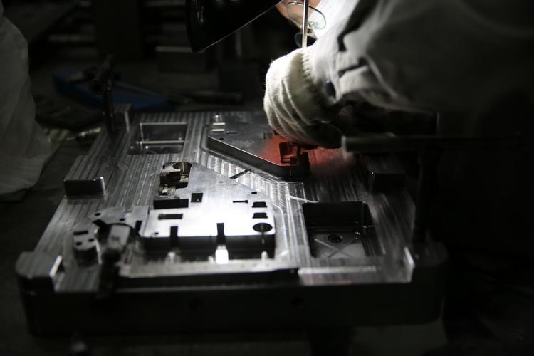 Engineers inspecting mold design drawings for accuracy